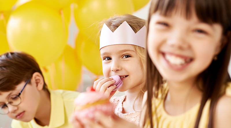 Sweet celebration Cute children eating sweets at birthday celebration